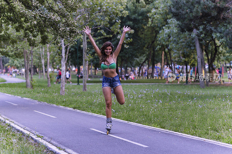 一个女人穿着溜冰鞋在公园里玩得很开心
