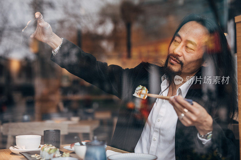 一名中国男子在吃寿司时自拍