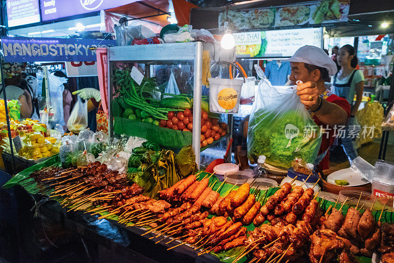 一个泰国女人在夜市卖街头小吃