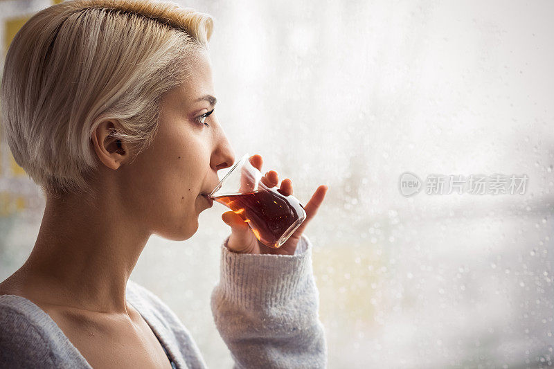 年轻女子在冬天喝热茶。