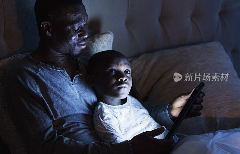 父亲用平板电脑给儿子读睡前故事