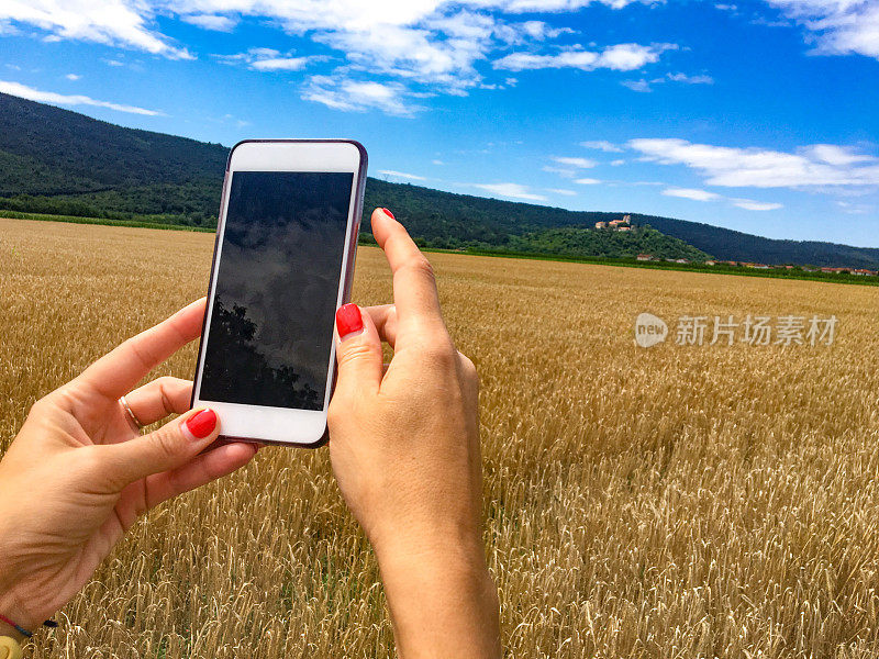 成年女性用智能手机拍摄风景