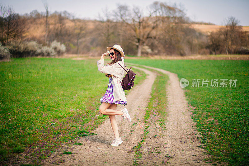 迷人的快乐女孩穿着衣服和帽子在户外