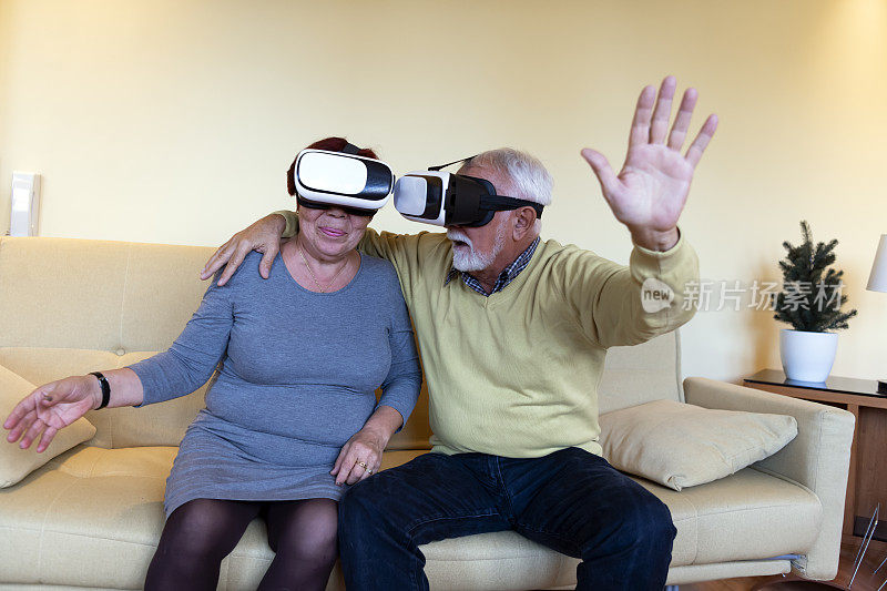 老年妇女和她的丈夫在家里玩虚拟现实游戏，把想象变成现实。