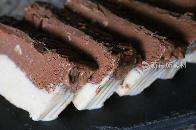 自制巧克力和椰子香草冰淇淋的棕色和白色切片的特写图像