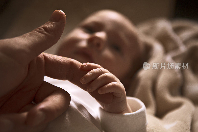 新生儿的手指握着父亲的手指