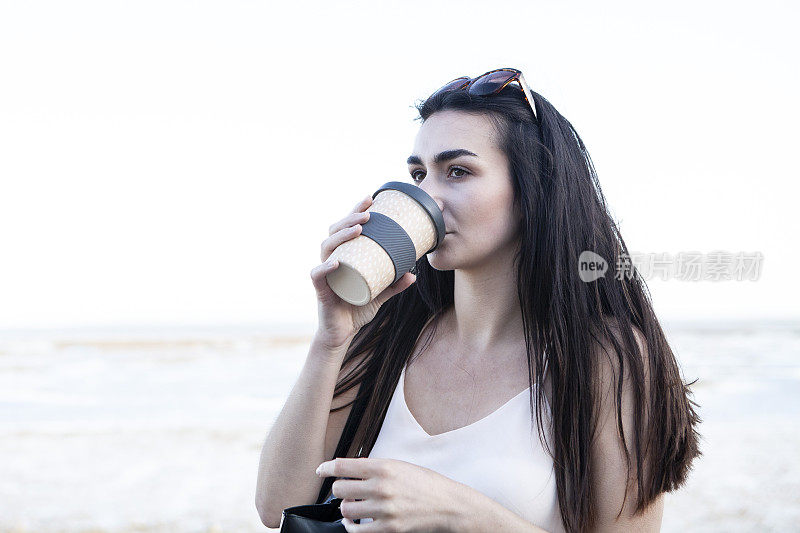 少女在海边喝着夏日午后的咖啡