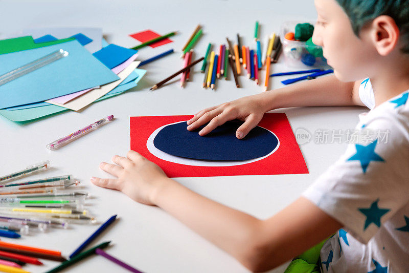孩子用彩色纸手工制作卡片。孩子们艺术和手工艺。
