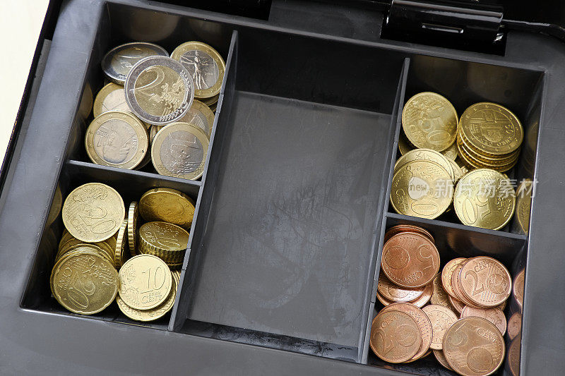 查看一个装有欧元硬币的现金箱。