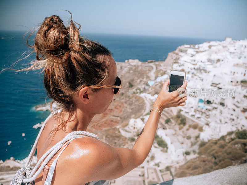 希腊圣托里尼岛，一名女子正在拍照