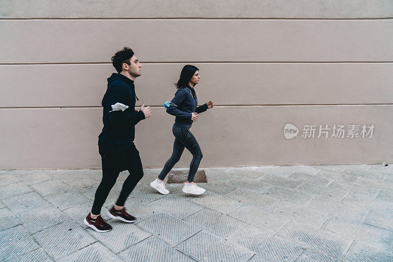 一对年轻夫妇在城市里一起跑步