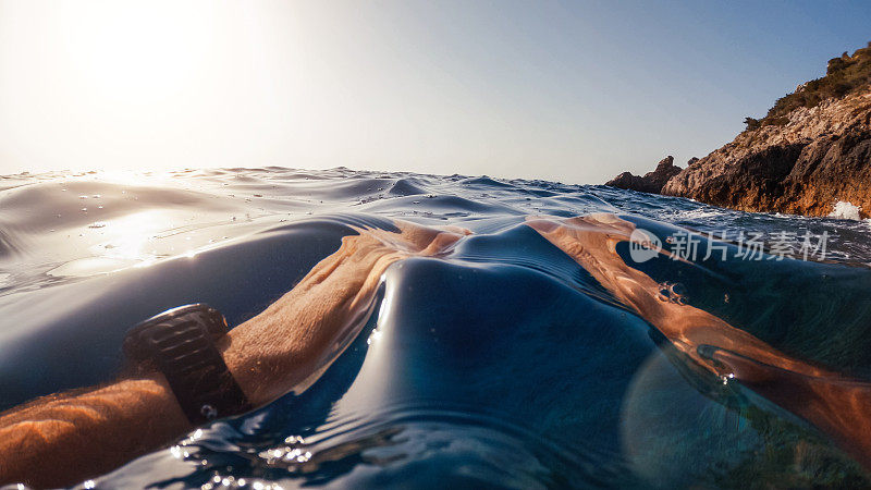 一个男人在夏天的海里游泳和浮潜