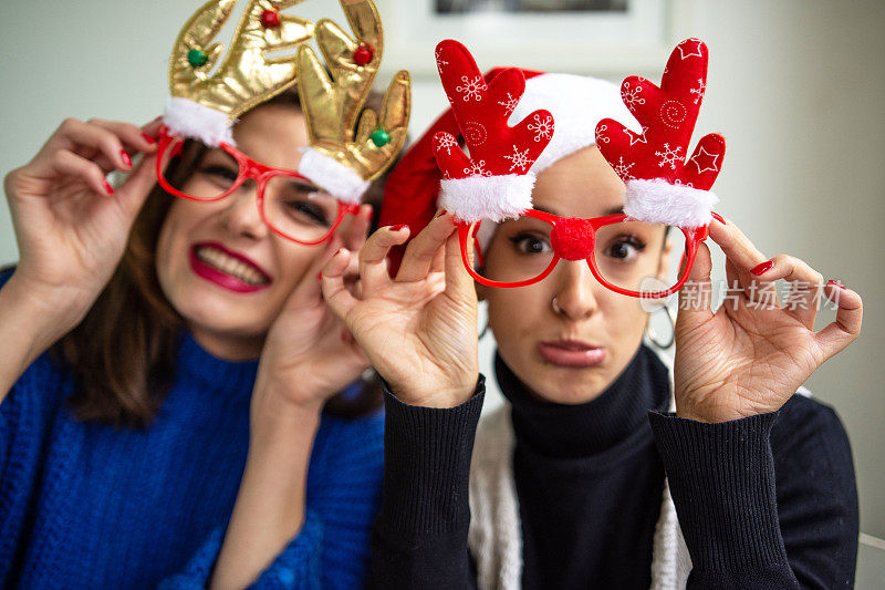 两个傻乎乎的年轻女人戴着有趣的圣诞眼镜