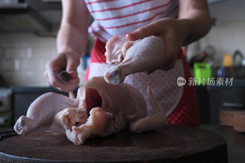 女人的手在切整只鸡