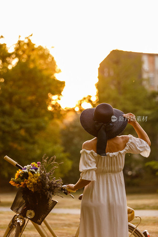 戴着太阳帽，穿着太阳裙的女人在看日落