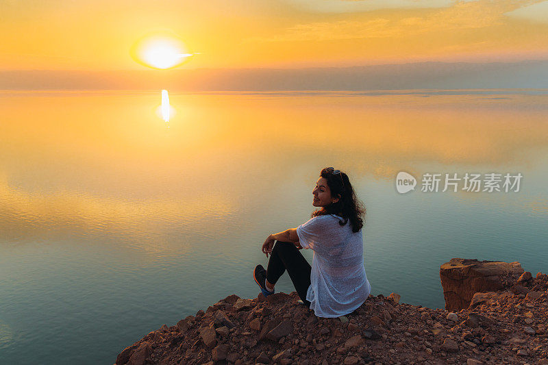 约旦死海上一个女人的剪影，她正在欣赏日落美景