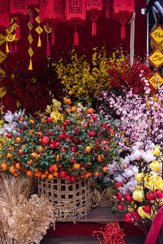 越南春节传统装饰。装饰塑料黄杏花，红色和镀金的装饰品在新年市场。