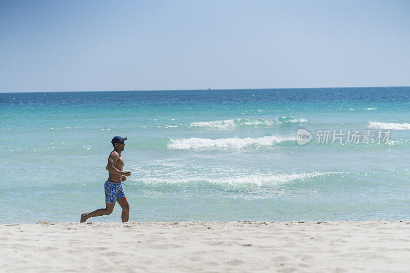 30岁的拉丁裔男子在迈阿密的海滩上慢跑