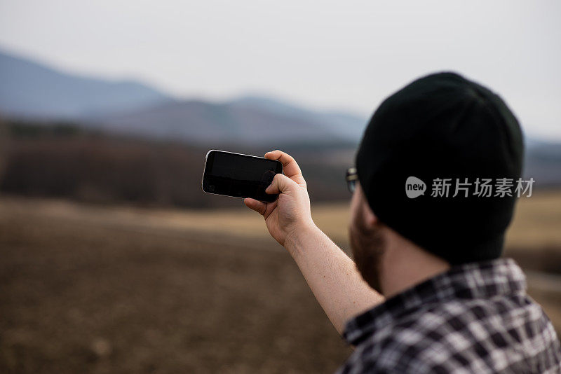 男人用手机拍照