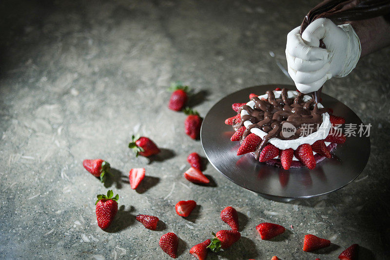 糕点大师在厨房准备草莓和巧克力蛋糕