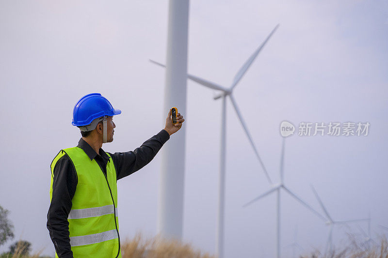 电力工地的蓝领工人。风车。