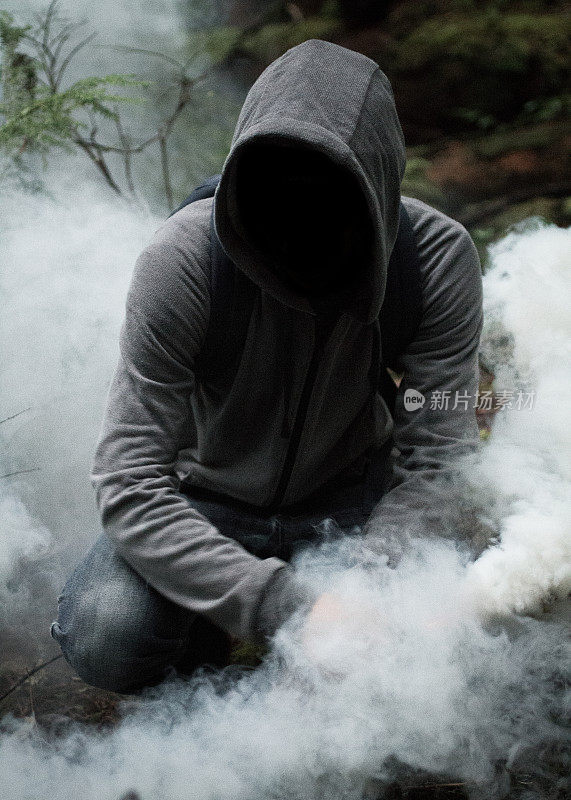 神秘男子在森林里拿着烟雾弹
