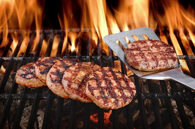 牛肉汉堡在热燃烧的烧烤木炭烤架上