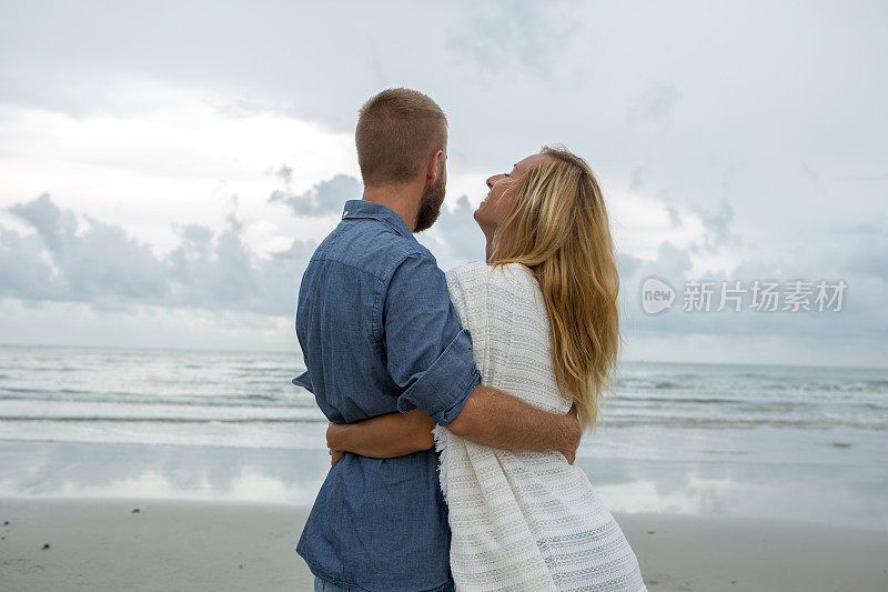 一对年轻的情侣在海滩上热情洋溢