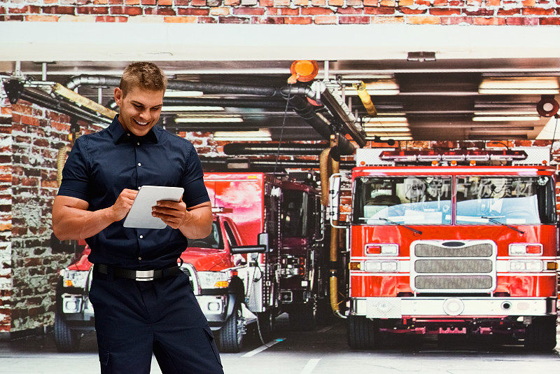 微笑的消防员在消防站使用平板电脑
