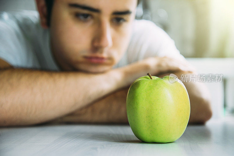 年轻人盯着苹果看