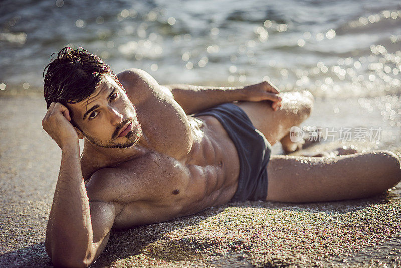 一个撕裂的男人躺在沙滩上的画面