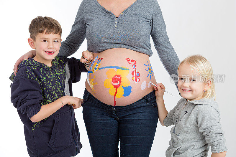 孩子们在他们怀孕的母亲的肚子上画画