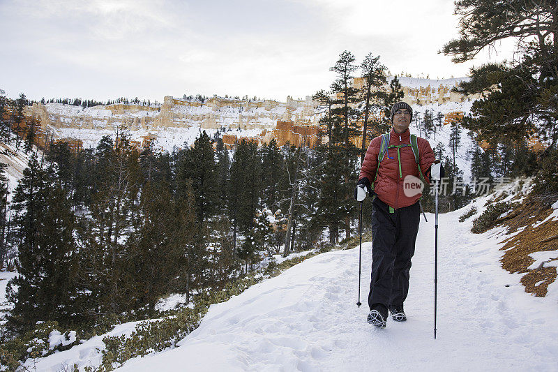 冬季徒步旅行者用冰爪在雪山景观上行走