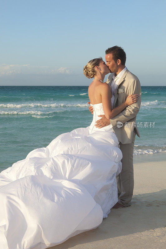 新郎和新娘在热带海滩接吻