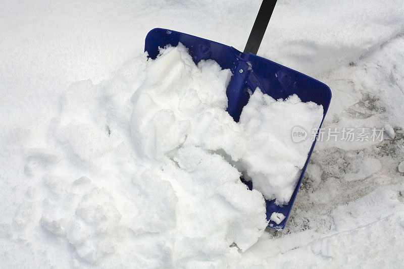 蓝色的雪铲在下雪的寒冷的冬天