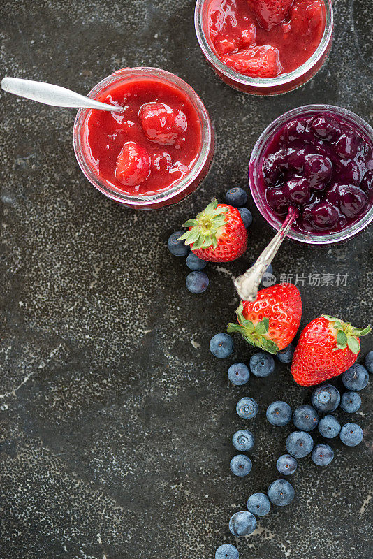 草莓和蓝莓果盘在玻璃容器石板背景