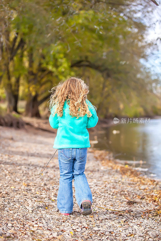 秋天里，少女在河边散步