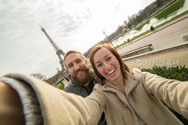 一对快乐的年轻夫妇在巴黎埃菲尔铁塔自拍