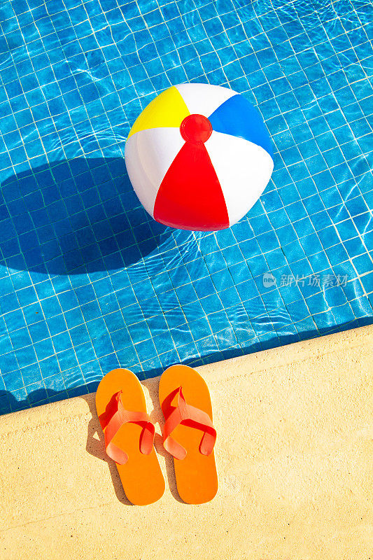 游泳池夏天的乐趣与浮动沙滩球，人字拖