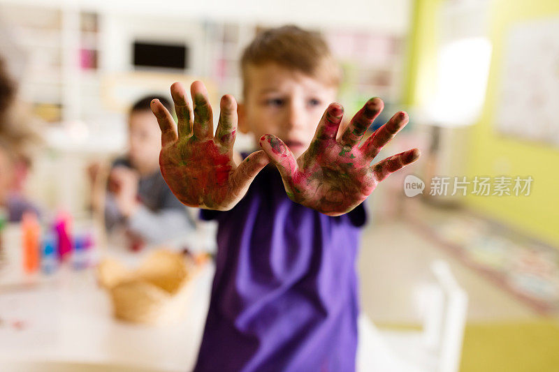 用水彩颜料画的小男孩的脏手。