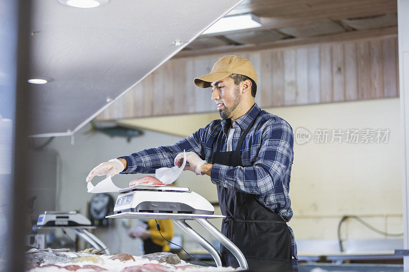 西班牙裔男子在海鲜市场给鱼称重