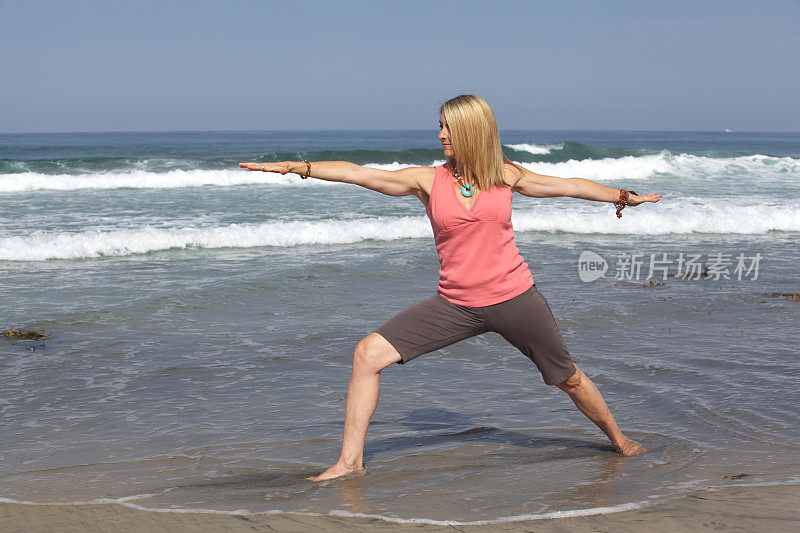 在海滩勇士姿势做瑜伽的女人