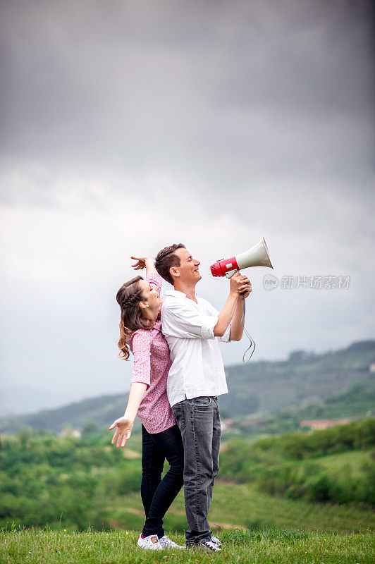 年轻夫妇用扩音器表达他们的爱