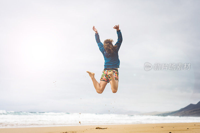 沙滩上欢呼的女孩跳了起来