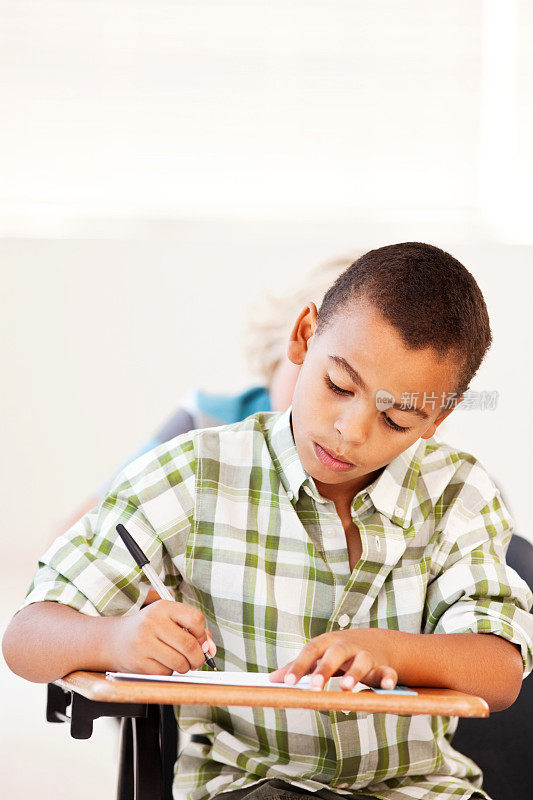 一个男生在教室里做笔记