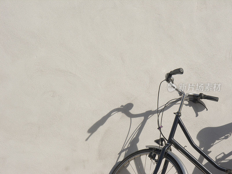 自行车;把自行车靠在奶油色的墙上