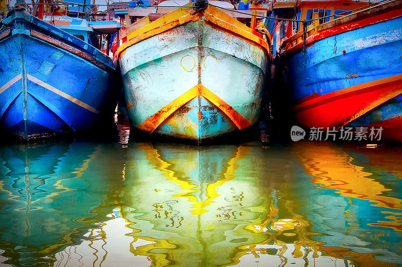 渔港里的一艘五颜六色的旧船。水中彩色的倒影。斯里兰卡。Tangalle。