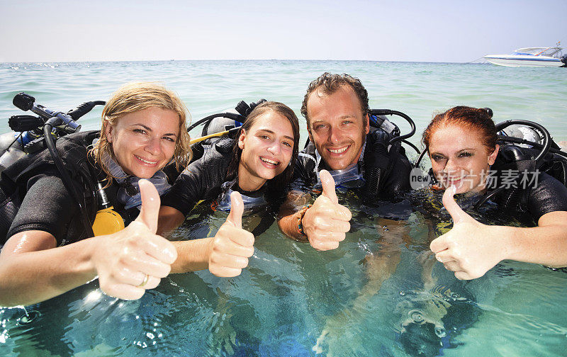 一群年轻的潜水员用手势表示ok。