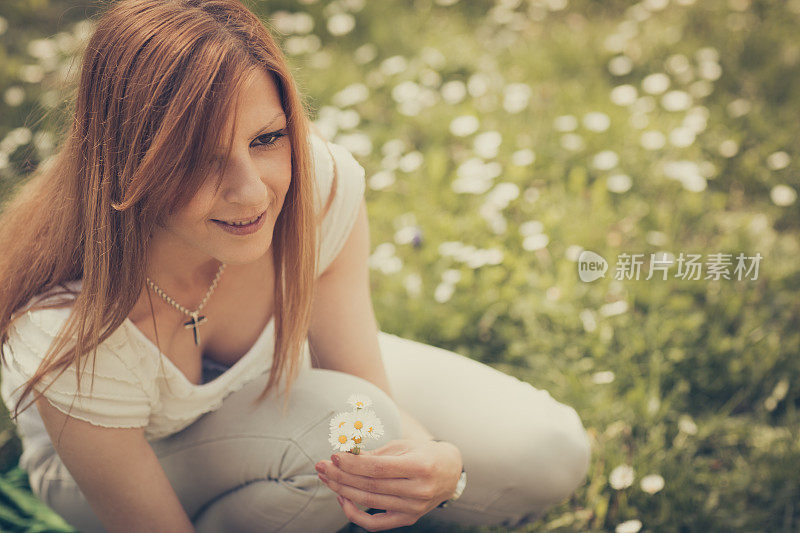 快乐的女孩在大自然中摘雏菊