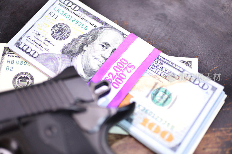9毫米手枪和一堆装在2000美元包装里的100美元钞票。